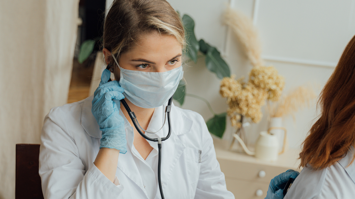 photo of a female docotr wearing a mask and gloves